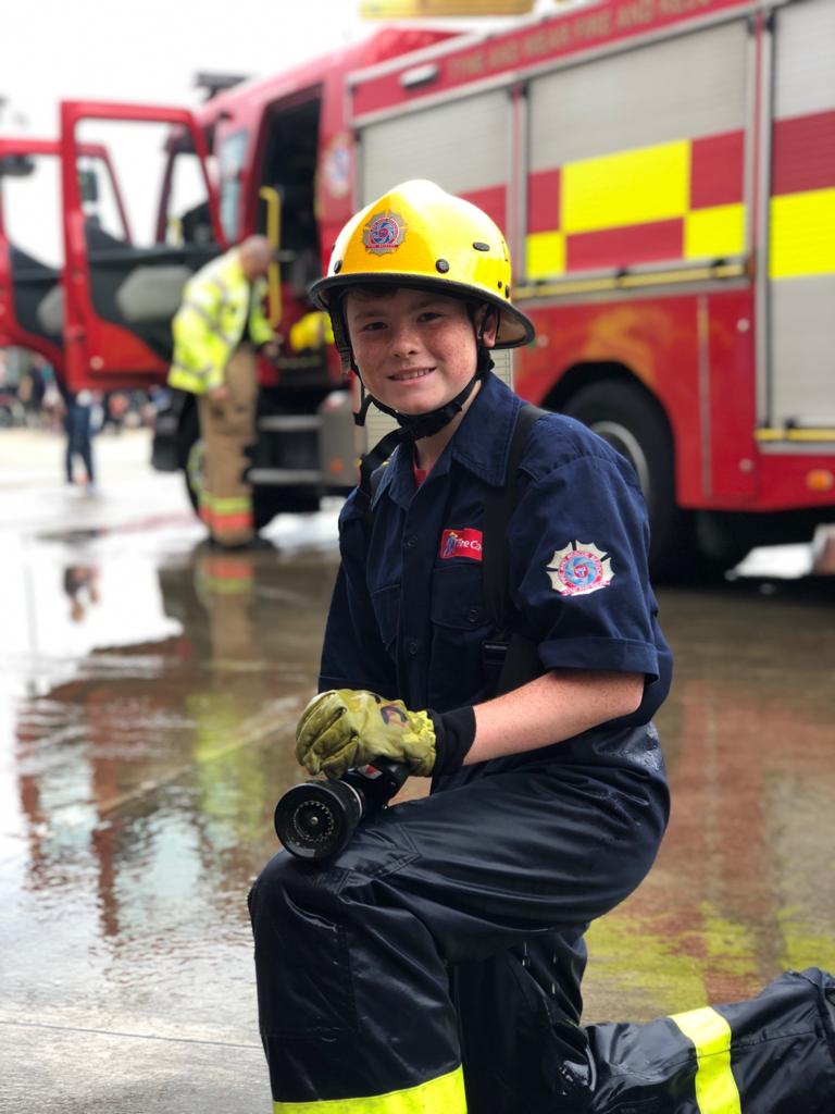 A fire cadet aims a hose