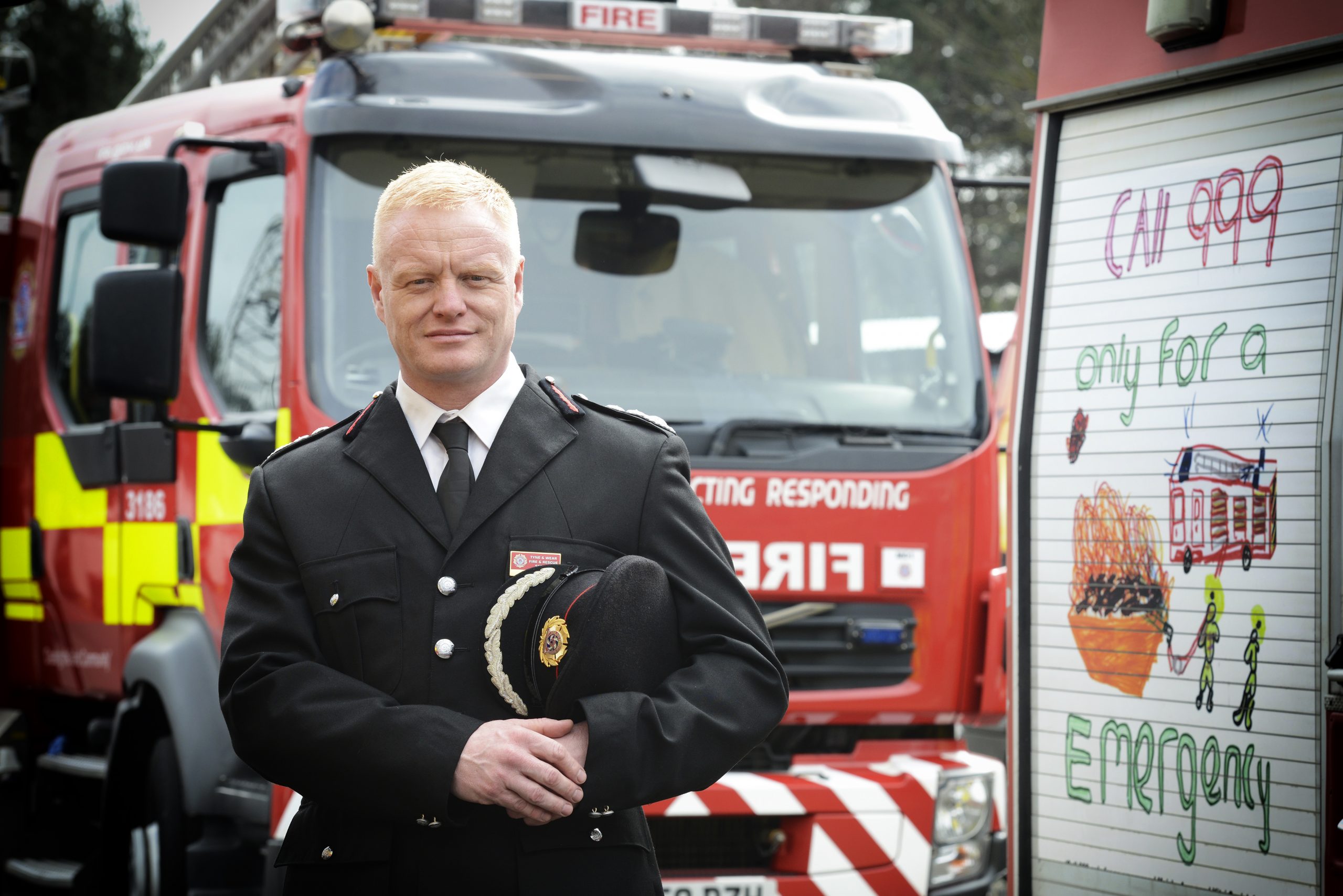 CFO Chris Lowther stands in front of a fire engine