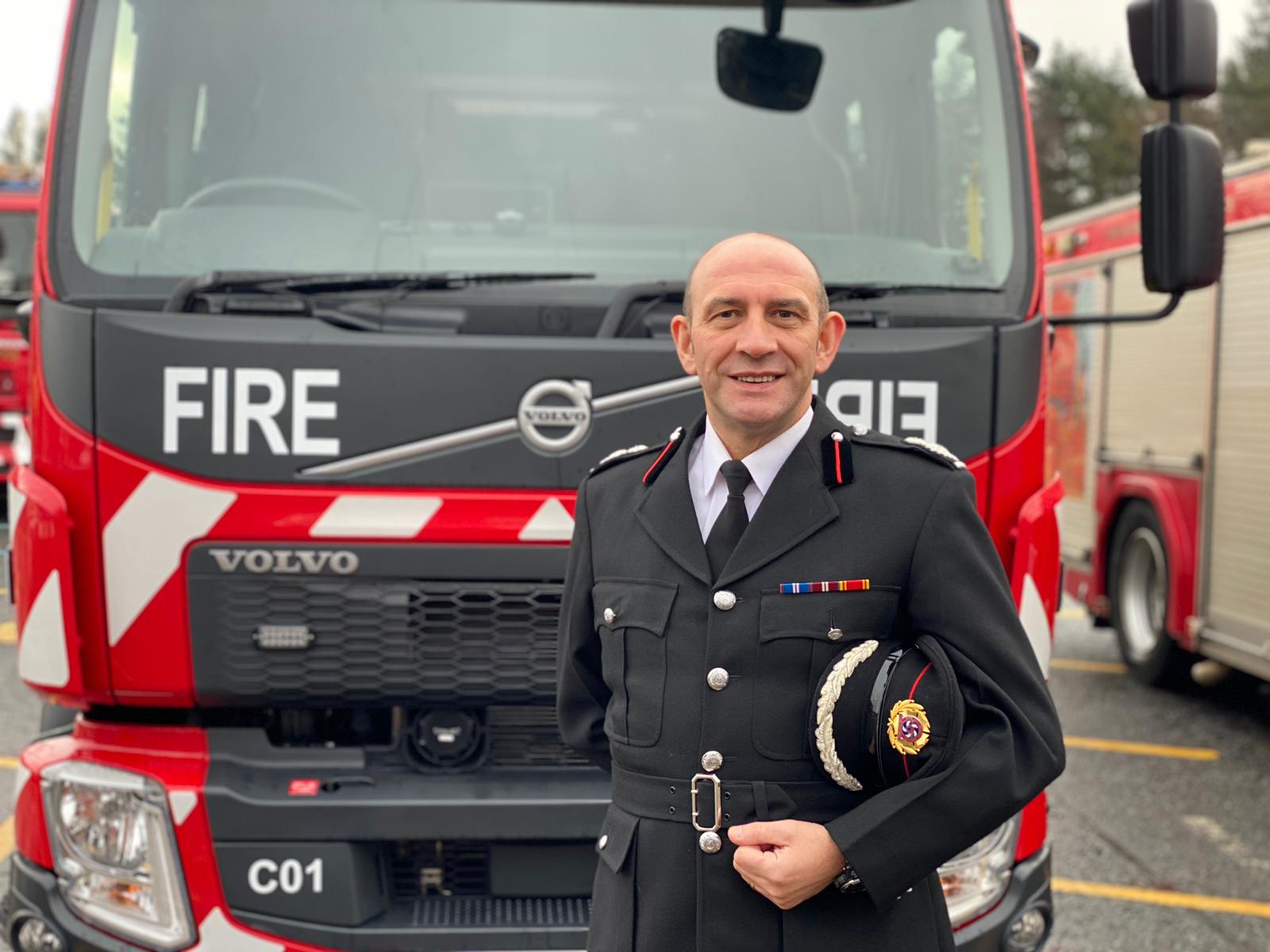 TWFRS Chief Fire Officer Peter Heath standing in front of a fire appliance