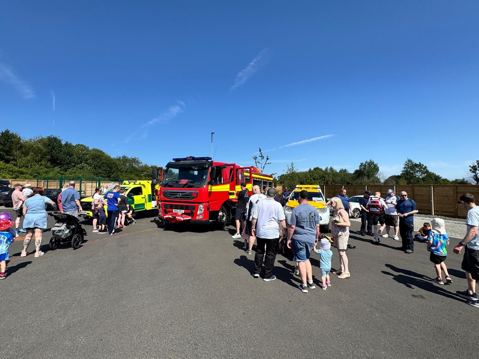 Crowd of people next to fire appliance at community event