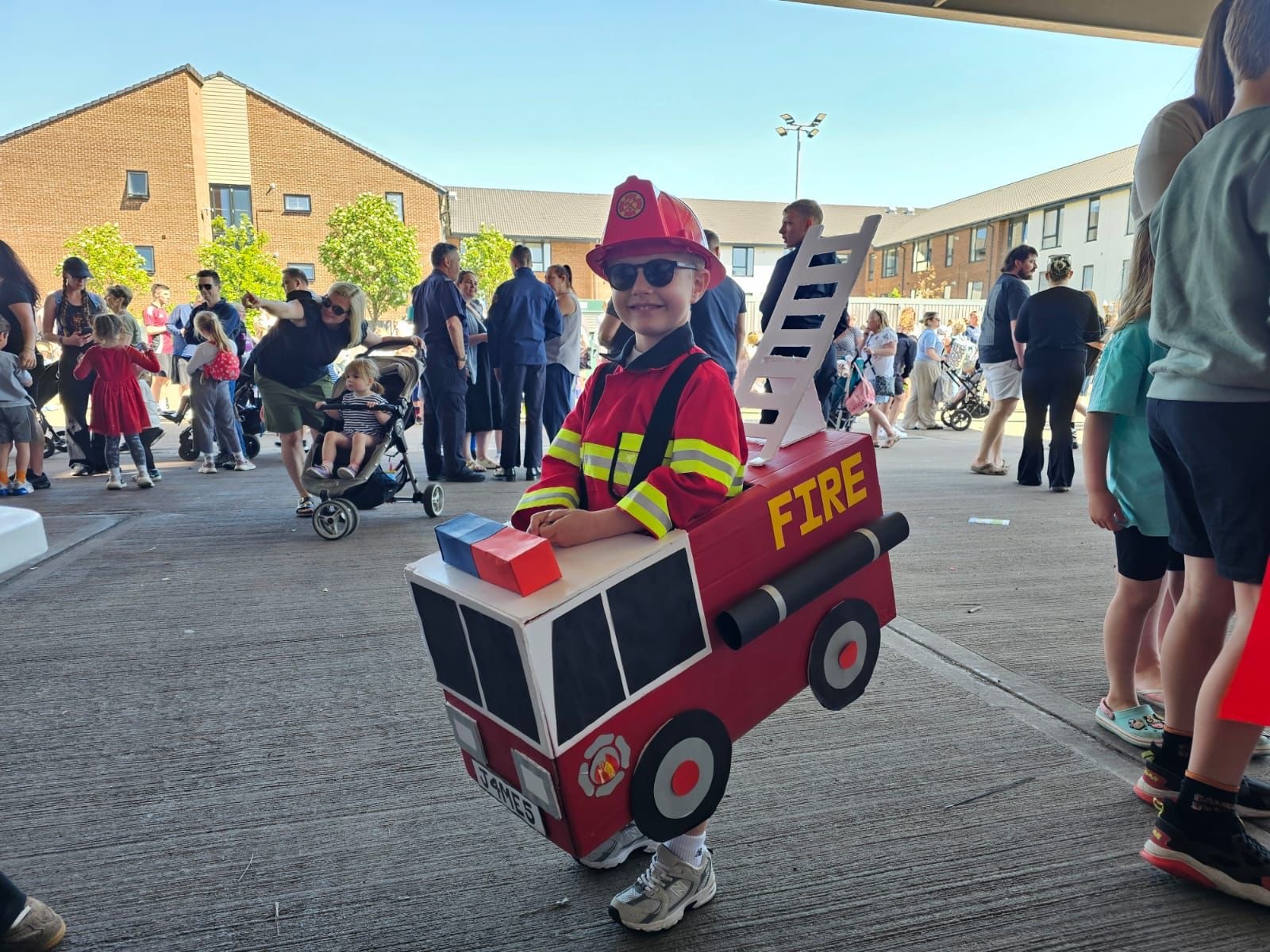 Child dressed as fire appliance at fire station open day event