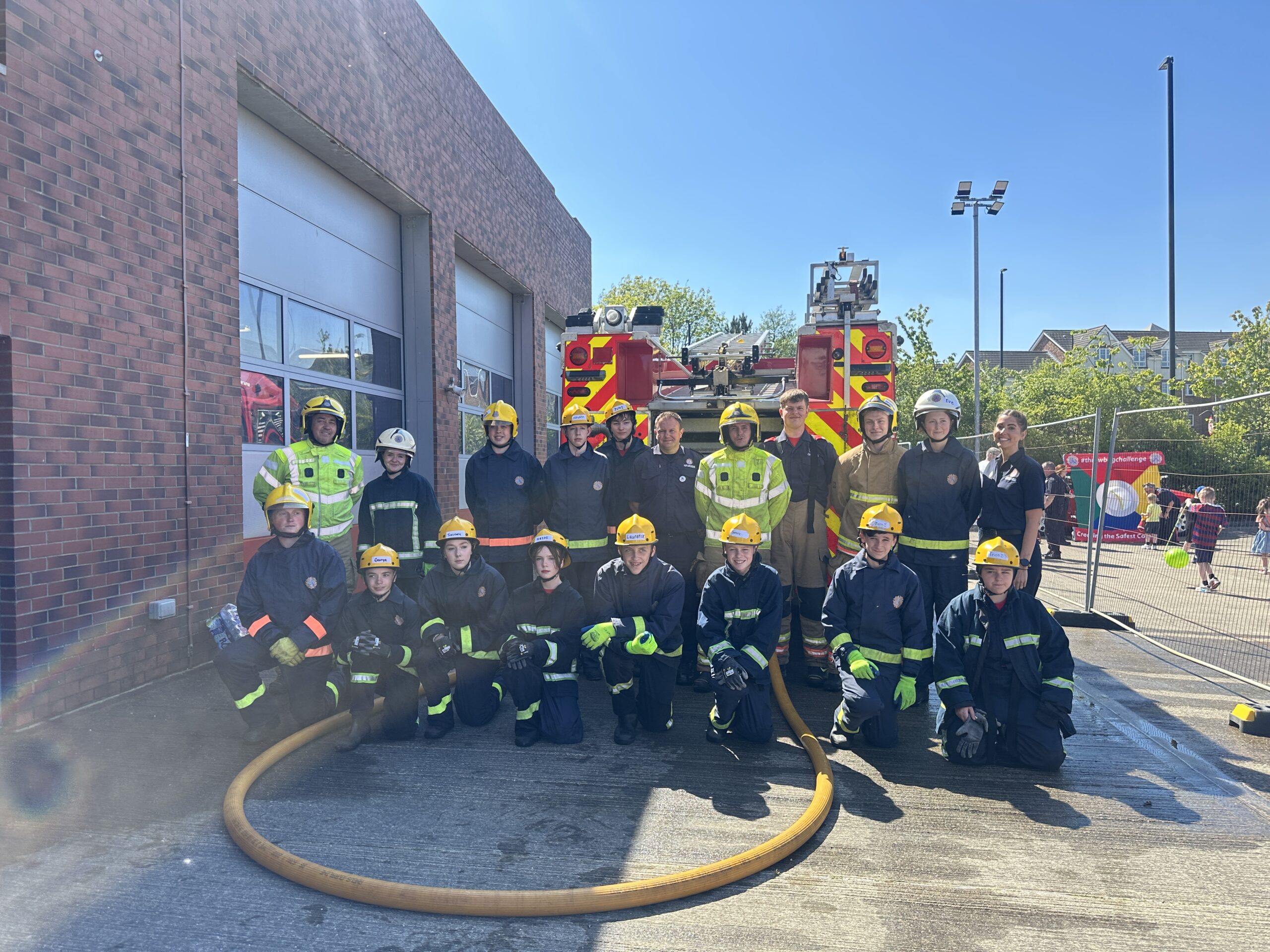 Group of Fire Cadets standing in front of fire appliance in drill yard
